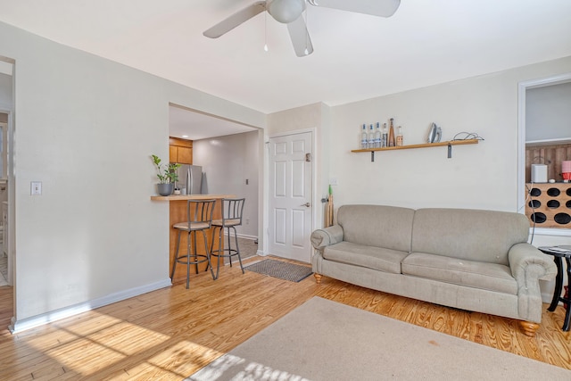 living room featuring ceiling fan and light hardwood / wood-style flooring