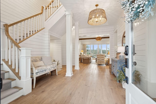 entrance foyer with a notable chandelier, decorative columns, and light hardwood / wood-style floors