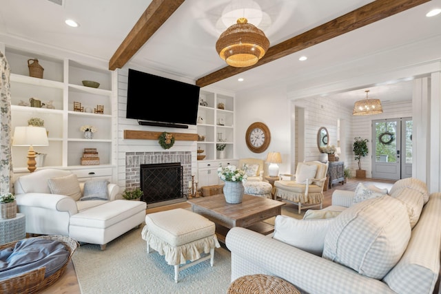 living room featuring beamed ceiling, hardwood / wood-style flooring, a fireplace, and built in shelves