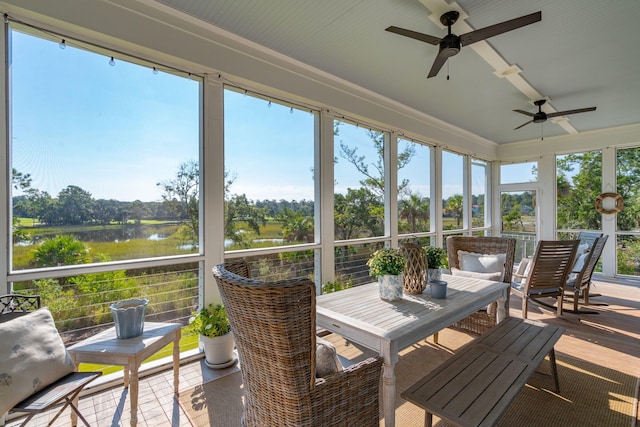 sunroom featuring a water view