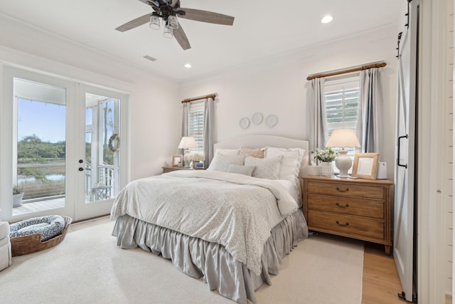 bedroom with french doors, crown molding, light hardwood / wood-style flooring, access to outside, and a barn door