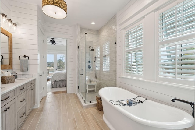 bathroom with ceiling fan, vanity, and independent shower and bath