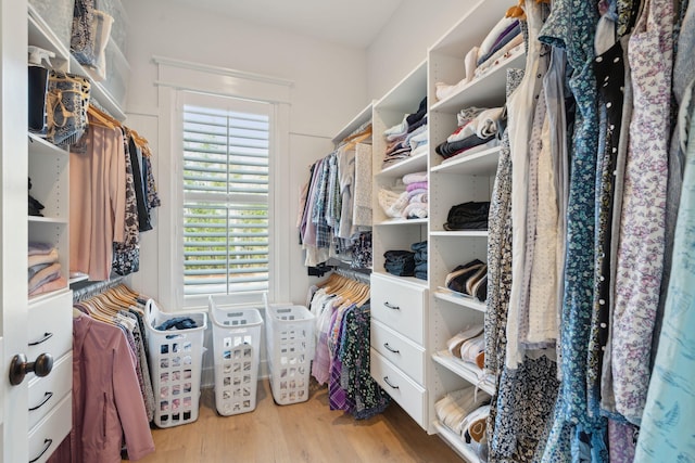 walk in closet with light hardwood / wood-style floors