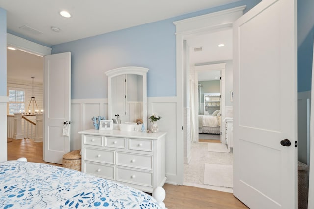 bedroom featuring an inviting chandelier and light hardwood / wood-style floors