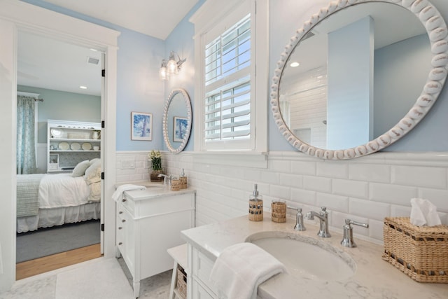 bathroom featuring vanity and tile walls