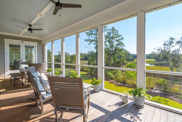 sunroom featuring a water view, ceiling fan, and plenty of natural light