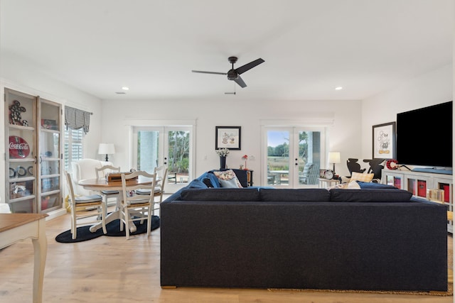 living room featuring light hardwood / wood-style flooring, french doors, ceiling fan, and plenty of natural light