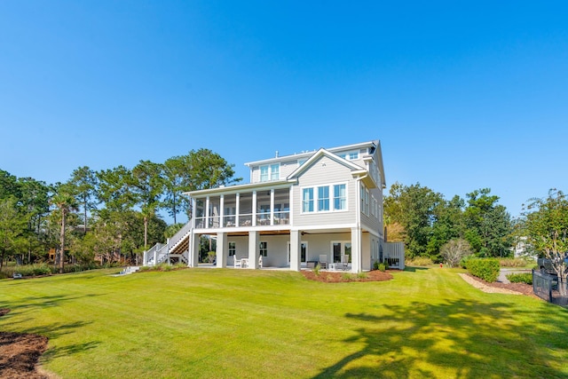 rear view of property with a sunroom, a yard, and a patio area