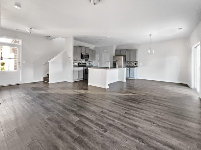 unfurnished living room with dark hardwood / wood-style flooring, sink, and a wealth of natural light