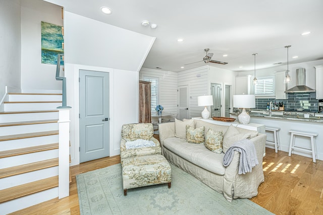 living room featuring ceiling fan, light hardwood / wood-style floors, and sink