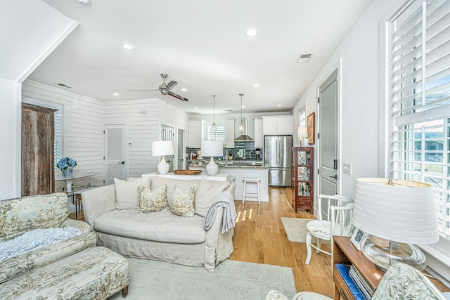 living room with ceiling fan and light hardwood / wood-style flooring