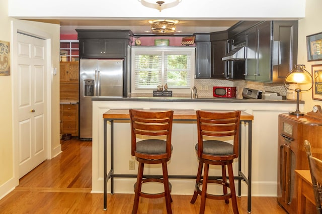 152 Mansfield Blvd, Charleston, SC 29418 - kitchen with stainless steel fridge, decorative backsplash, light wood-type flooring, a breakfast bar, and light countertops