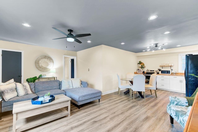 living area with light wood-style flooring, recessed lighting, a ceiling fan, and baseboards