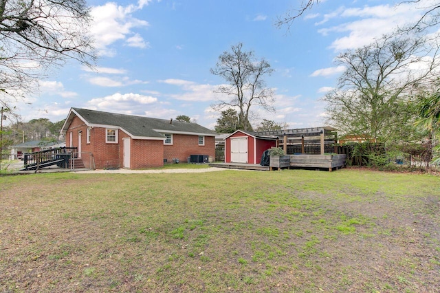 rear view of property with an outbuilding, a shed, a pergola, a lawn, and brick siding