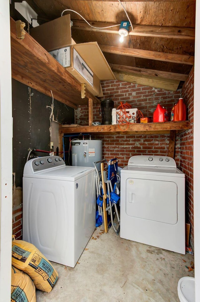 laundry area with washing machine and clothes dryer, brick wall, laundry area, and water heater