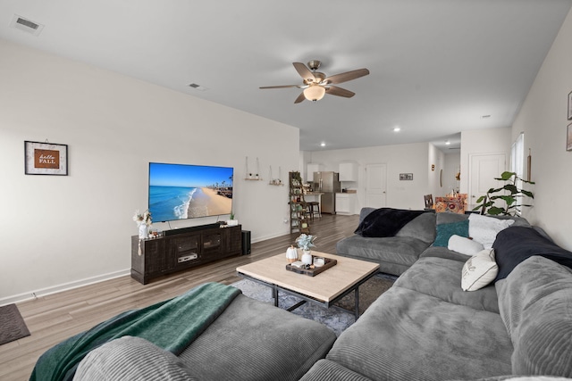 living room with ceiling fan and hardwood / wood-style flooring