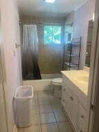 full bathroom featuring tile floors, vanity, toilet, and shower / bath combo with shower curtain