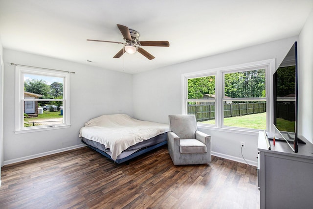 bedroom featuring baseboards, multiple windows, and dark wood-style flooring