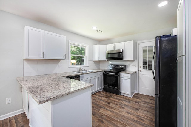 kitchen featuring decorative backsplash, a peninsula, dark wood-style floors, a sink, and appliances with stainless steel finishes