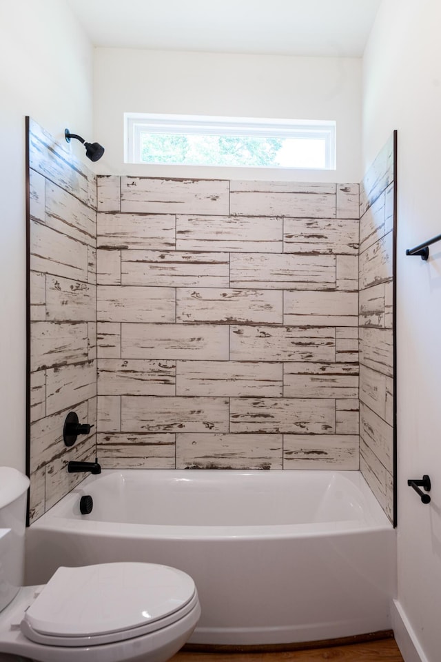 bathroom with toilet, tub / shower combination, and a healthy amount of sunlight