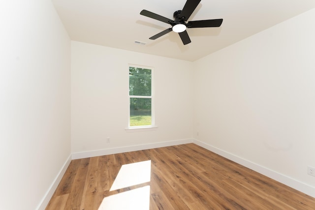 spare room with light wood-style floors, a ceiling fan, baseboards, and visible vents