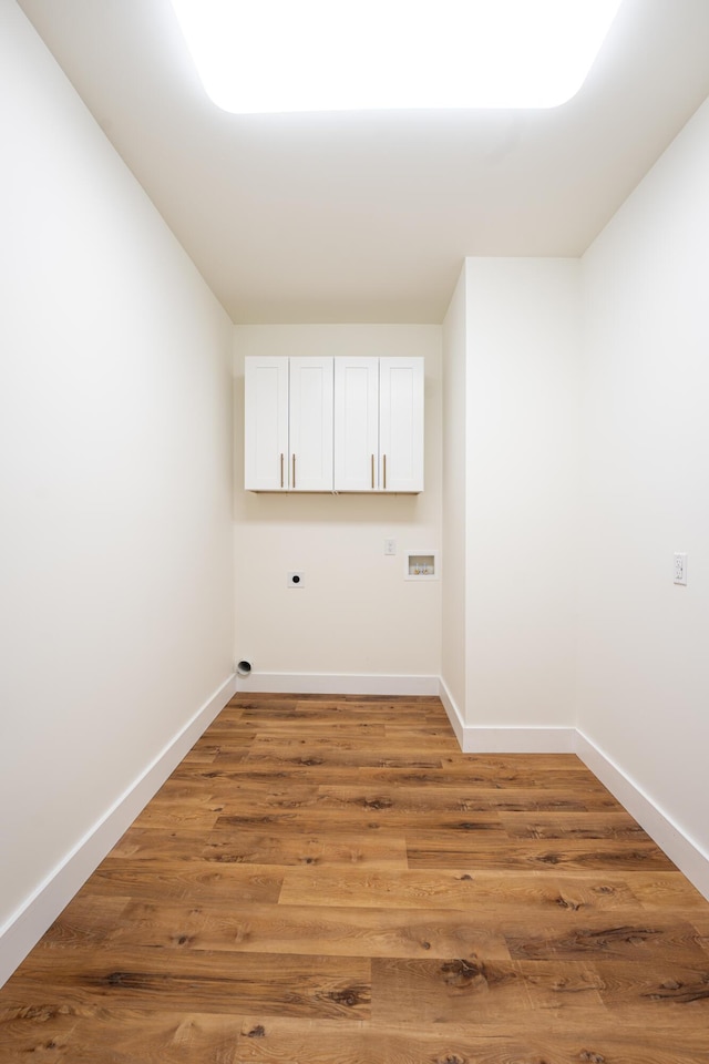 spare room featuring baseboards and light wood finished floors