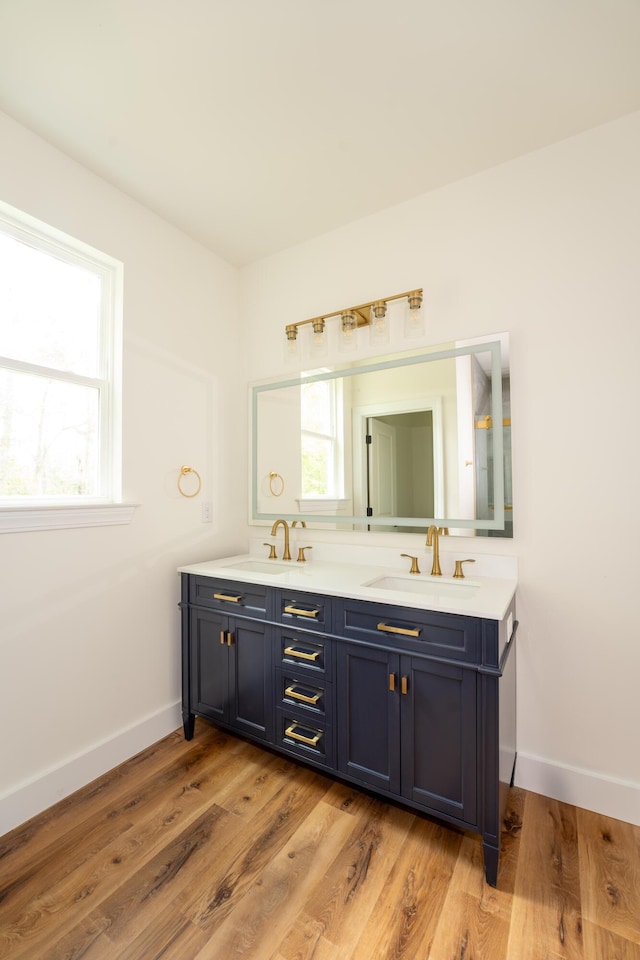 bathroom with double vanity, baseboards, and a sink