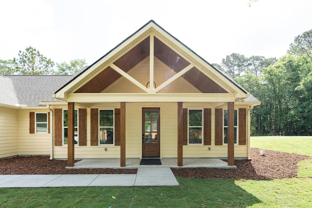 view of front of home featuring covered porch and a front lawn