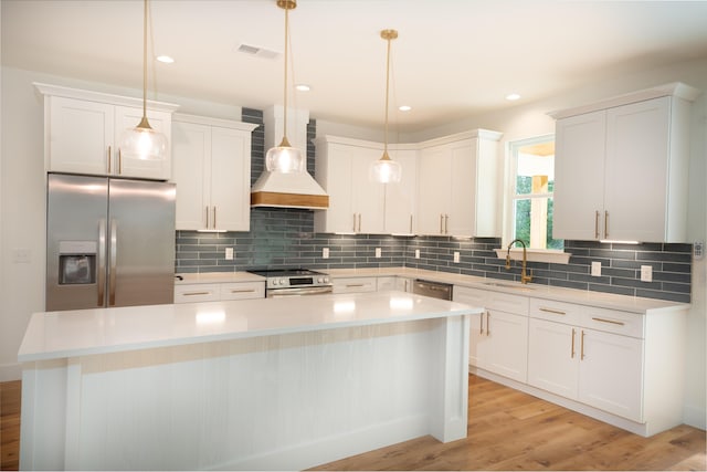 kitchen featuring a sink, a center island, stainless steel appliances, decorative backsplash, and custom range hood