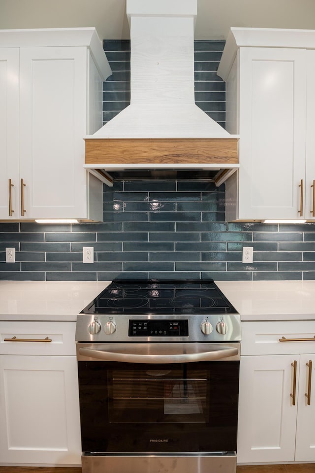 kitchen featuring white cabinets, light countertops, electric stove, tasteful backsplash, and custom exhaust hood