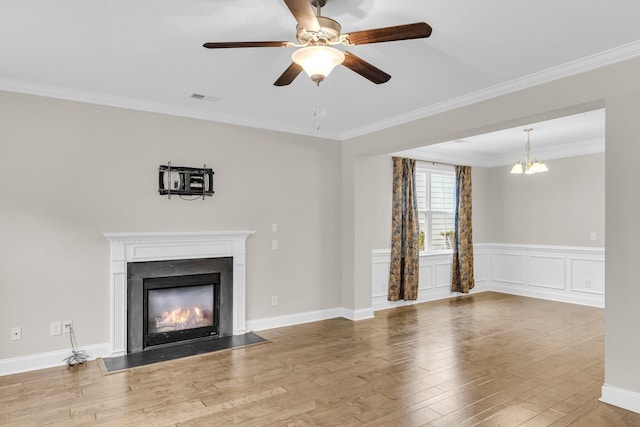 unfurnished living room with wood-type flooring, ceiling fan with notable chandelier, and crown molding