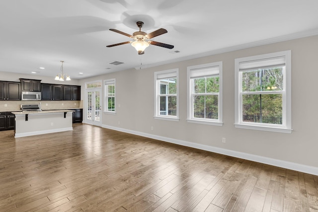 unfurnished living room featuring ceiling fan, ornamental molding, and light hardwood / wood-style floors