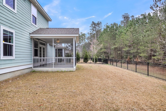 view of yard featuring ceiling fan and a sunroom