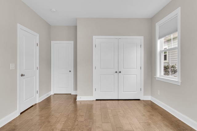 unfurnished bedroom featuring light hardwood / wood-style floors and a closet