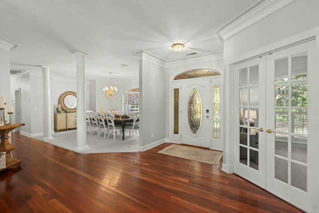 foyer entrance with dark hardwood / wood-style floors, french doors, crown molding, and a chandelier