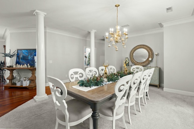 dining area with a chandelier, light wood-type flooring, decorative columns, and ornamental molding