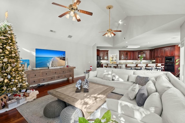 living room with high vaulted ceiling and light wood-type flooring