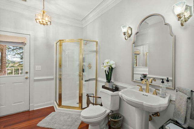 bathroom with wood-type flooring, toilet, a shower with door, and ornamental molding