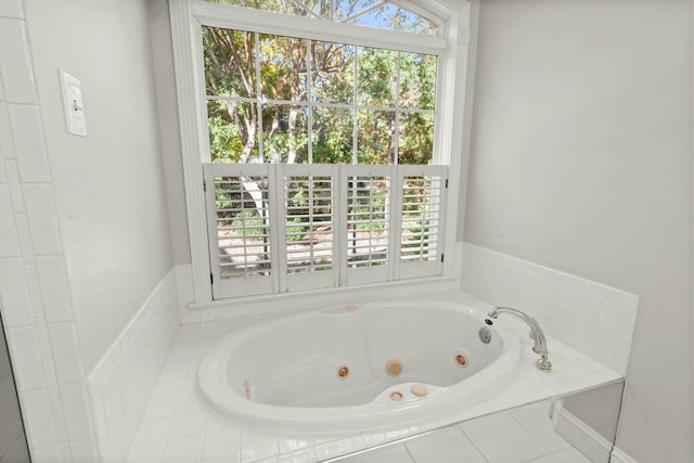 bathroom featuring plenty of natural light and tiled bath