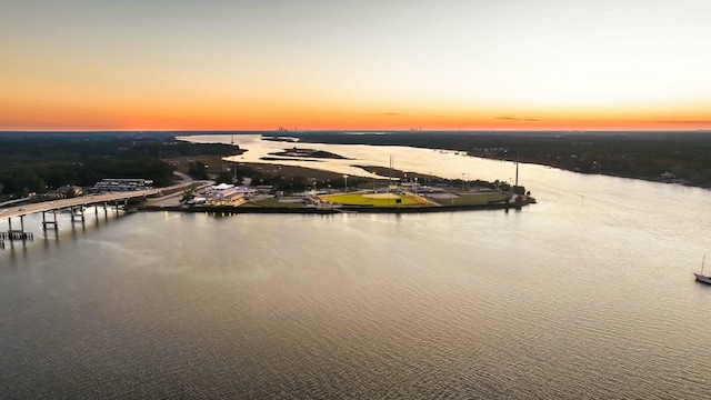 aerial view at dusk featuring a water view