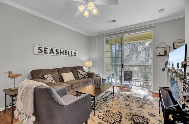 living room featuring crown molding, visible vents, ceiling fan, wood finished floors, and baseboards