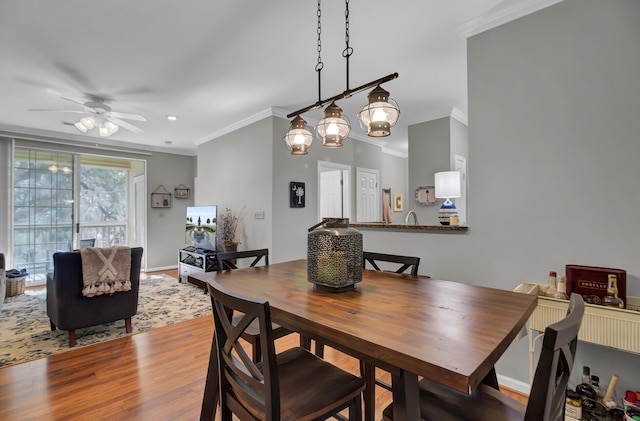 dining area with baseboards, ceiling fan, ornamental molding, and wood finished floors