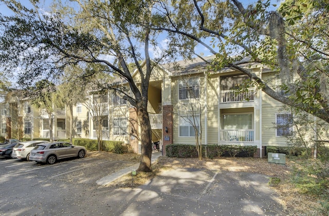 townhome / multi-family property featuring uncovered parking and brick siding