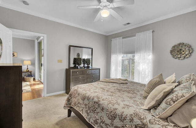 bedroom featuring light carpet, baseboards, visible vents, ceiling fan, and ornamental molding