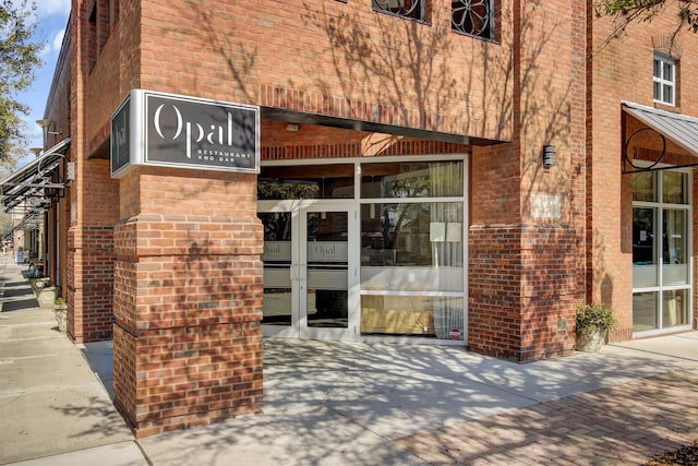 doorway to property featuring brick siding