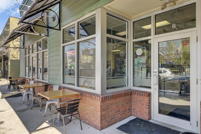 property entrance featuring brick siding and a patio