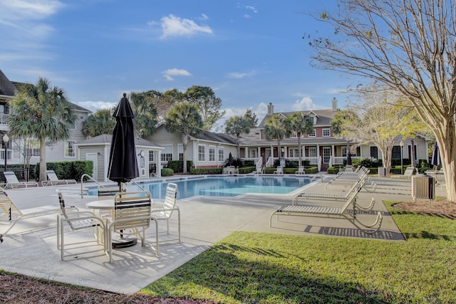 pool with a patio and a yard