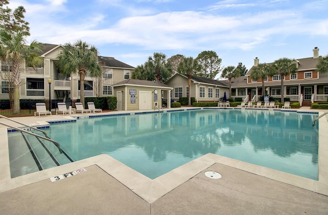 pool with a patio and fence