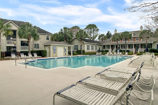 community pool with fence and a patio