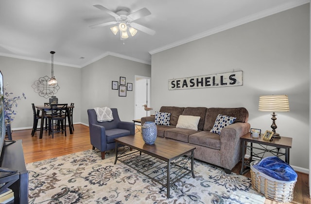 living room with ceiling fan, baseboards, wood finished floors, and crown molding